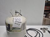 une bouteille de propane, munie d'un tuyau, posée sur une table