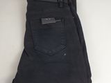 a pair of black jeans hanging on a white wall