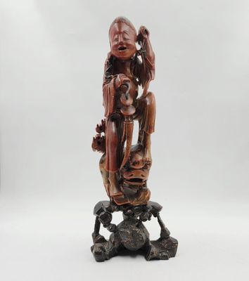 une statue en bois représentant une femme tenant un enfant sur un rocher
