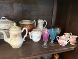 many cups and saucers on a shelf in a room