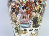 a vase with a painting on it sitting on a table