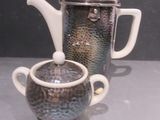 une théière et une tasse posées sur une table