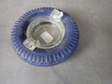 un cendrier en verre bleu contenant un morceau de papier carré
