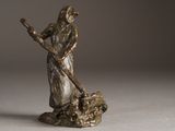 bronze statue of a woman with a staff on a white surface