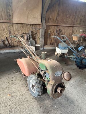 un petit tracteur et une petite tondeuse dans un garage