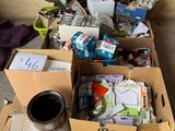 une boîte remplie d'objets posée par terre à côté d'une pile de boîtes