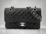 un sac Chanel noir auquel est suspendue une chaîne