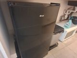 a black refrigerator in the corner of a kitchen