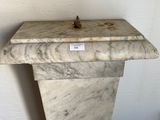a white marble pedestal with a sign on it