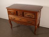 a small wooden chest of drawers on a table