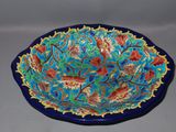 a blue bowl with red and green designs on it