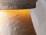 a close up of a stone vase with a yellow light on it