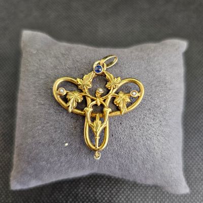 une image représentant une croix en or sertie d'une pierre bleue