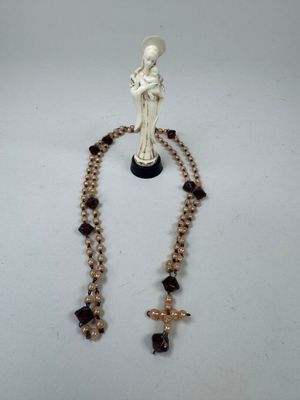 collier orné d'une statuette représentant une femme tenant une croix et un chapelet