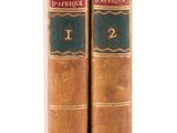 two old books sitting on top of each other on a white surface