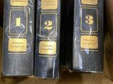 three books are in a box on a table