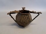 un petit vase marron surmonté d'un oiseau
