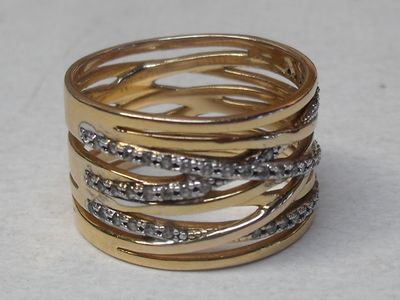 a close up of a gold and diamond ring on a table