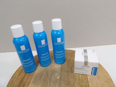 three bottles of lotion sitting on a cutting board