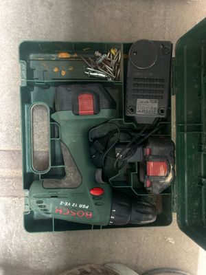 une boîte verte contenant des outils, avec une personne debout à côté