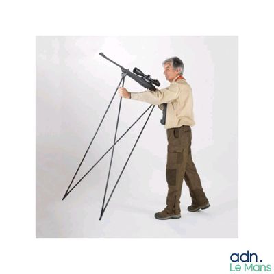 un homme tenant un fusil posé sur un trépied