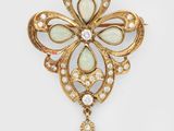 un pendentif en forme de croix en opalite et diamants