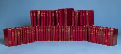 plusieurs livres rouges empilés les uns sur les autres sur une surface bleue