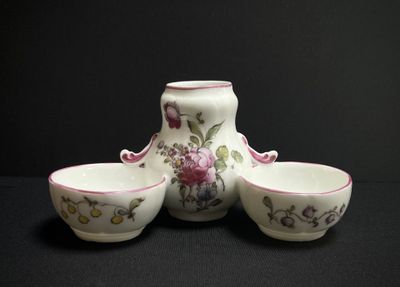 three bowls and a vase sitting on a table