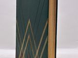 an open book with a green cover and gold lines on it