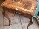 a small table with a wooden top sitting on a sidewalk