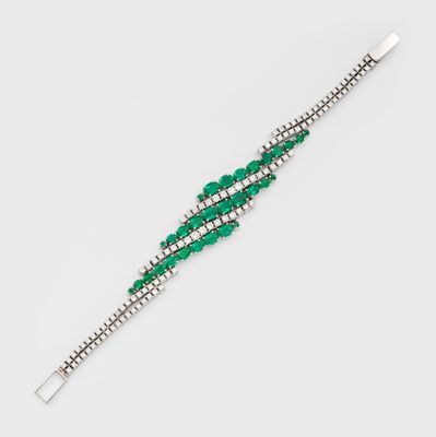 un gros plan d'un bracelet vert et blanc posé sur une surface blanche