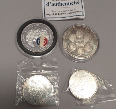 some silver coins are sitting on a table next to a sign