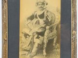 an old photo of a woman sitting in a chair with a dog