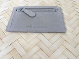 grey leather card case with a zipper on top of it