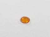 an oval shaped orange sapphire stone on a white surface