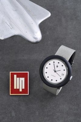 une montre et un livre posés sur une table à côté d'un avion