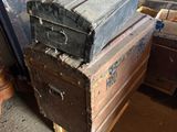many old trunks stacked on top of each other in a room