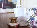 two vases on a table next to a vase with flowers on it