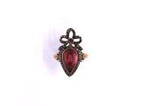 a close up of a ring with a red stone in it