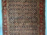 un vieux tapis accroché au mur d'une pièce bleue