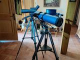a blue telescope on a tripod in a living room