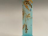 a blue glass vase with yellow flowers on it