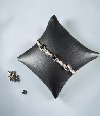 a close up of a black pillow with a ring on top of it