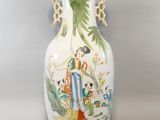 a white vase with a painting on it sitting on a table