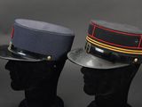two military hats on a mannequin head on a black background