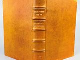 un vieux livre avec une couverture dorée et une couverture marron