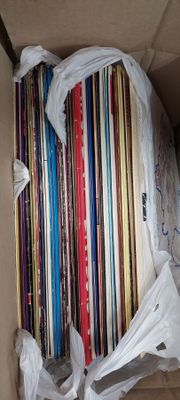 a cardboard box with a bunch of cds in it
