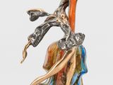statue d'une femme tenant une fleur, posée sur un socle