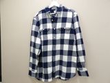 the shirt is hanging on a hanger on the wall