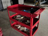 un chariot de chantier rouge chargé d'outils, dans un garage